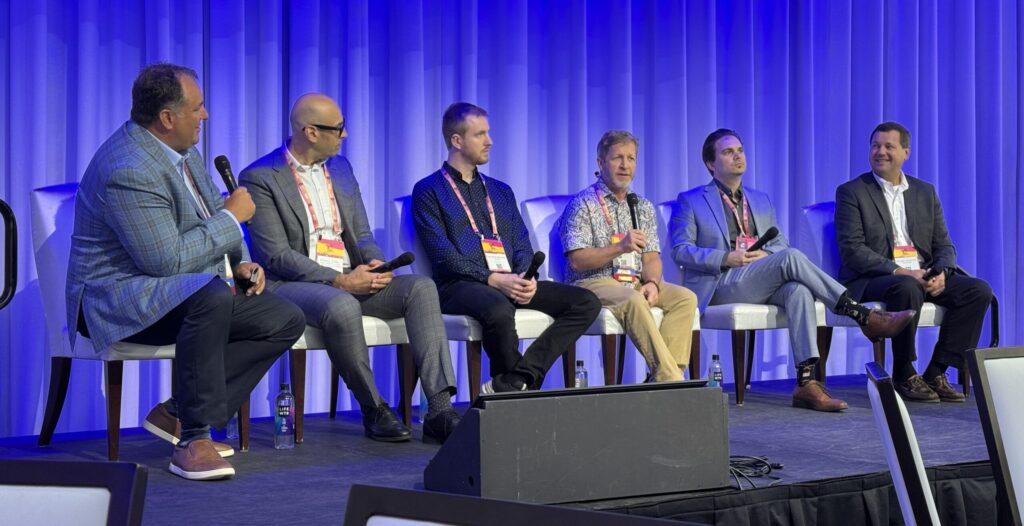 A panel of six industry subject matter experts seated on stage discussing digital twins.